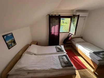 a small bedroom with two beds and a window at Vila kraljice Teute in Jezero