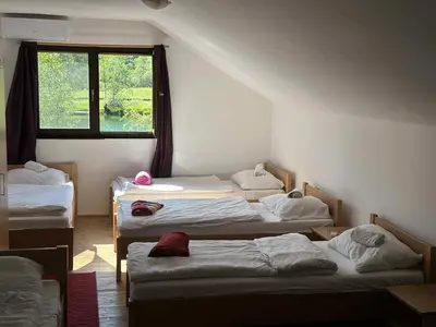 a room with four beds in it with a window at Vila kraljice Teute in Jezero