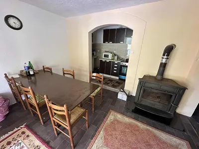 a dining room with a table and a wood stove at Vila kraljice Teute in Jezero