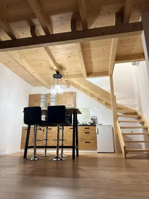 a dining table with two chairs in a room with stairs at Vikendica Diva