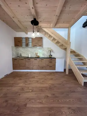 a kitchen with a staircase in a room with wooden floors at Vikendica Diva