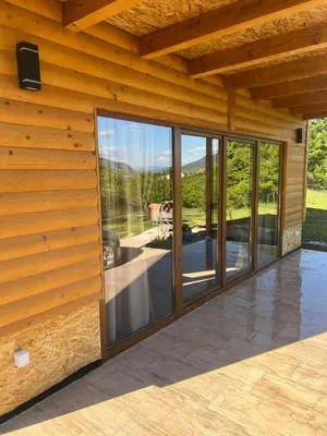 a room with glass doors on a wooden wall at Vikendica Diva