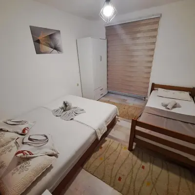 a bedroom with two beds and a door with a window at Oaza mira BK in Bosanska Krupa