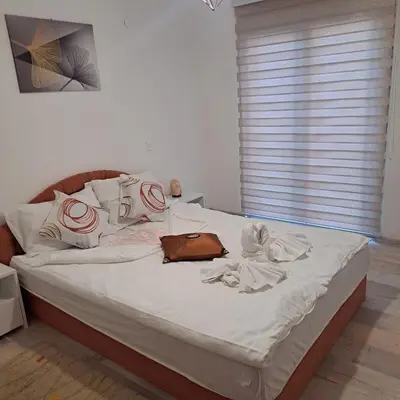 a bed with white sheets and a purse on it at Oaza mira BK in Bosanska Krupa