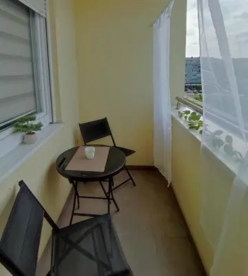 a small table and chairs in a room with a window at Urban escape in Doboj