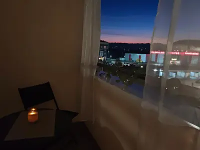 a candle sitting on a table in front of a window at Urban escape in Doboj