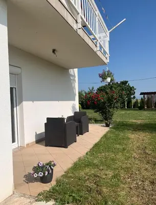 a patio with two couches and flowers next to a building at Apartman Delminium in Tomislavgrad