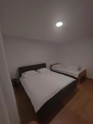a bedroom with two beds and a light on the ceiling at Apartman Delminium in Tomislavgrad