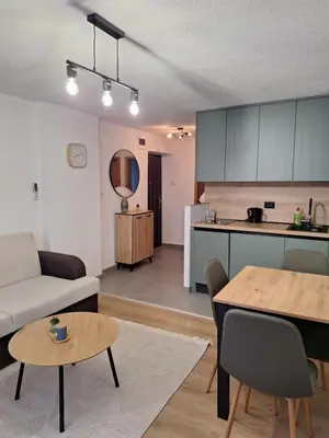 a living room and kitchen with a couch and a table at Apartman KULA Livno in Livno