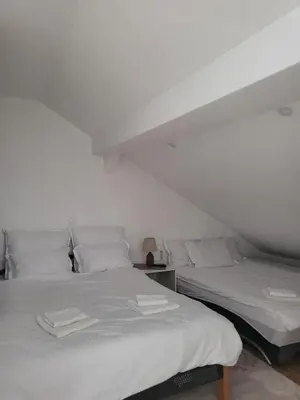 two beds sitting next to each other in a room at Apartman MM in Bihać