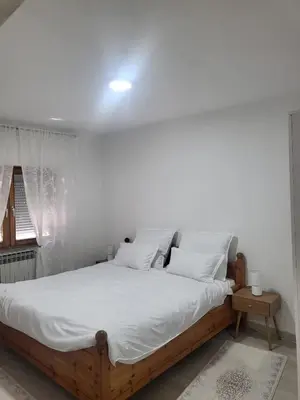 a bedroom with a bed with white sheets and a window at Apartman MM in Bihać