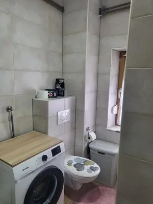 a small bathroom with a washing machine and a toilet at Apartman MM in Bihać