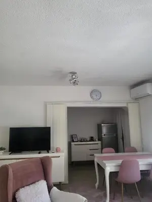 a living room with a couch and a table and a tv at Apartman MM in Bihać