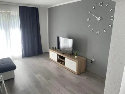 a living room with a tv and a clock on the wall at Apartman BOBA in Jajce