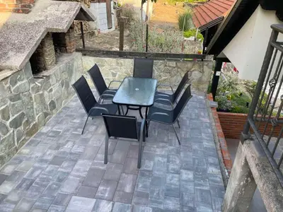 a patio with a table and chairs on a stone wall at Apartman BOBA in Jajce