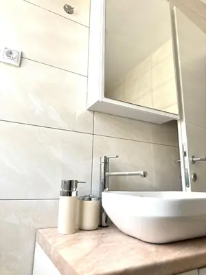 a bathroom with a sink and a mirror at Apartman Gold Jajce in Jajce