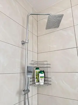 a shower with a rack with cleaning products on it at Apartman Gold Jajce in Jajce