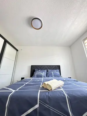 a bedroom with a bed with a blue comforter at Apartman Gold Jajce in Jajce