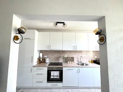 a kitchen with white cabinets and a sink at Apartman Gold Jajce in Jajce