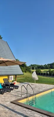 a swimming pool next to a house at Vikendica Buzadzija M&N