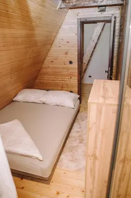 a small room with a bed in a wooden cabin at Vikendica Buzadzija M&N