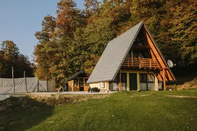 a house with a gambrel roof on top of a yard at Vikendica Buzadzija M&N