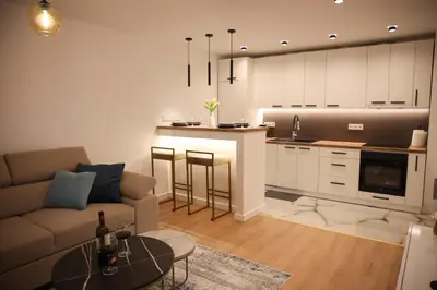 a living room and kitchen with a couch and a table at Apartman Nikola in Livno