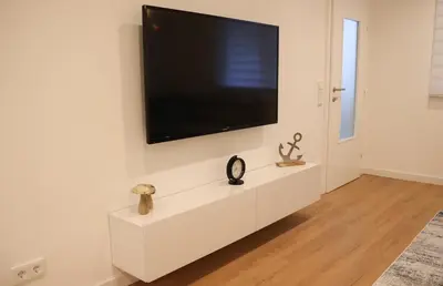 a white cabinet with a flat screen tv on a wall at Apartman Nikola in Livno