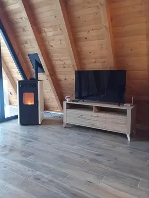 a living room with a flat screen tv and a wood stove at Villa Rustic