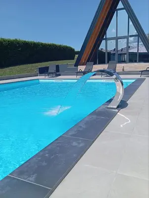 a swimming pool with a water fountain at Villa Rustic