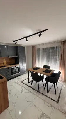 a kitchen with a table and chairs in a room at White house Paradise in Bihać
