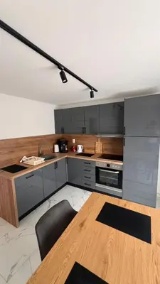 a kitchen with gray cabinets and a wooden table at White house Paradise in Bihać