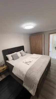 a bedroom with a large bed with white sheets at White house Paradise in Bihać