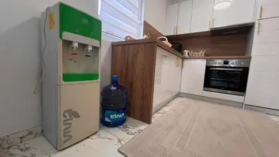 a kitchen with a bottle of water next to a refrigerator at White house Paradise in Bihać