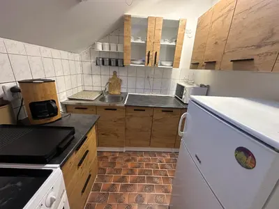 a small kitchen with a sink and a refrigerator at Stan Travnik in Travnik