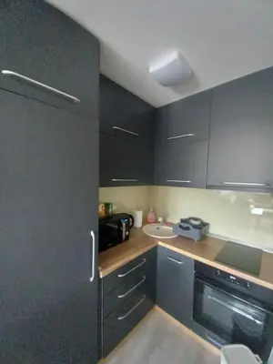 a small kitchen with black cabinets and a sink at Apartman Jana 2 in Doboj