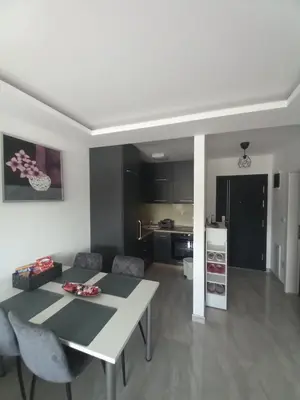 a kitchen and living room with a white table and chairs at Apartman Jana 2 in Doboj
