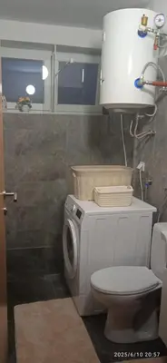 a bathroom with a toilet and a washing machine at Apartman ANNA in Jajce