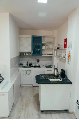 a kitchen with white cabinets and a black counter top at Apartman Suada in Fojnica