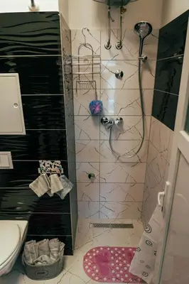 a bathroom with a shower with a sink and a toilet at Apartman Suada in Fojnica