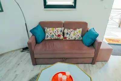 a brown couch with pillows and a table in a living room at Apartman Suada in Fojnica