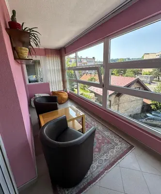 a living room with two chairs and a table and a window at Apartment Bella - Tuzla, Mejdan in Tuzla