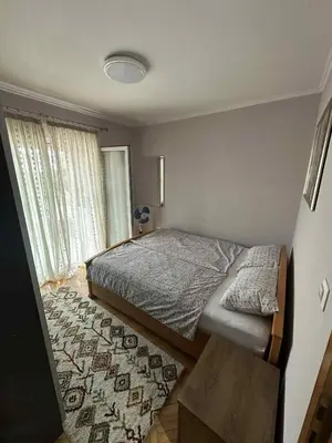 a bedroom with a bed and a rug at Apartment Bella - Tuzla, Mejdan in Tuzla