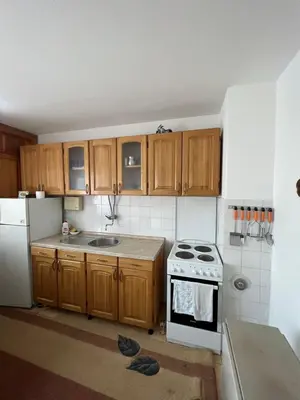 a kitchen with wooden cabinets and a white stove top oven at Royal Travnik in Travnik