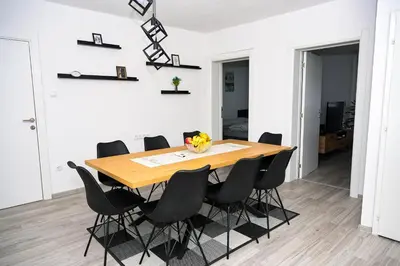 a dining room with a wooden table and black chairs at Apartman Castello in Jajce
