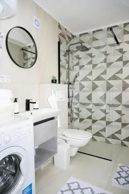 a bathroom with a toilet and a sink and a washing machine at Apartman Castello in Jajce