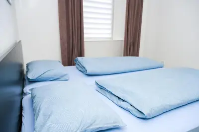 two beds in a room with blue pillows on them at Apartman Castello in Jajce