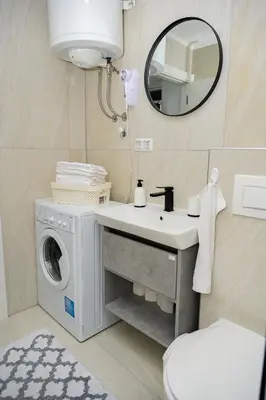 a bathroom with a washing machine and a sink at Apartman Castello in Jajce