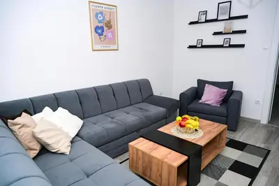a living room with a blue couch and a table at Apartman Castello in Jajce