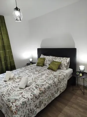 a bedroom with a large bed with green pillows at Apartman David in Jajce